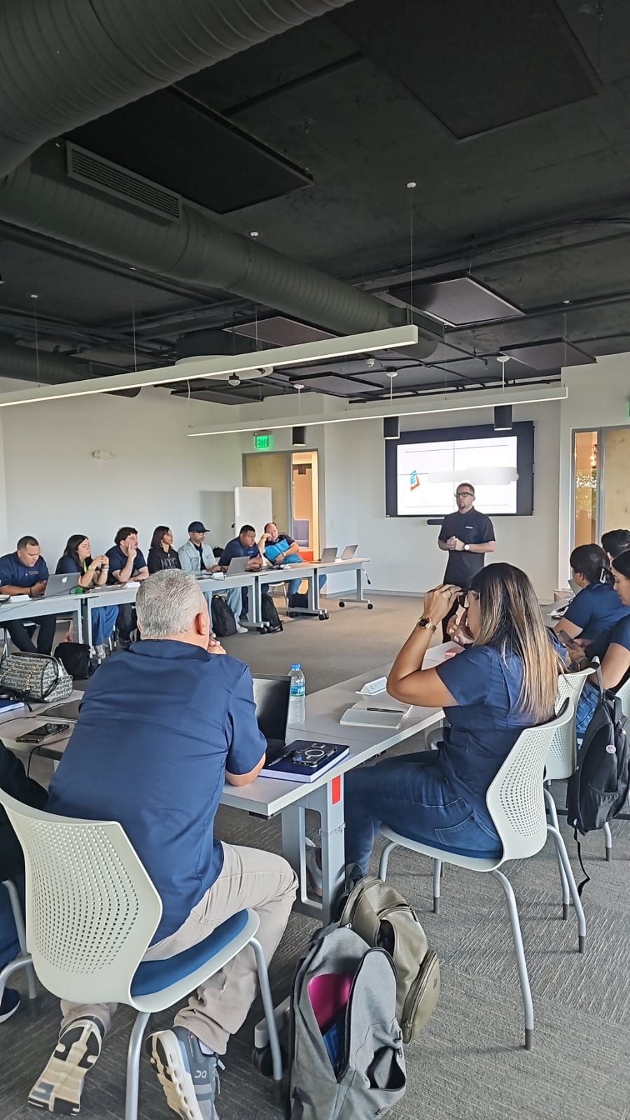 Express team seated around a conference room during a presentation, with a screen behind the presenter